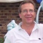 Smiling man with a blue sculpture background.