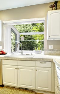 A kitchen with white cabinets and a sink.