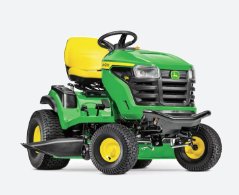 A green and yellow lawn mower sitting on top of grass.