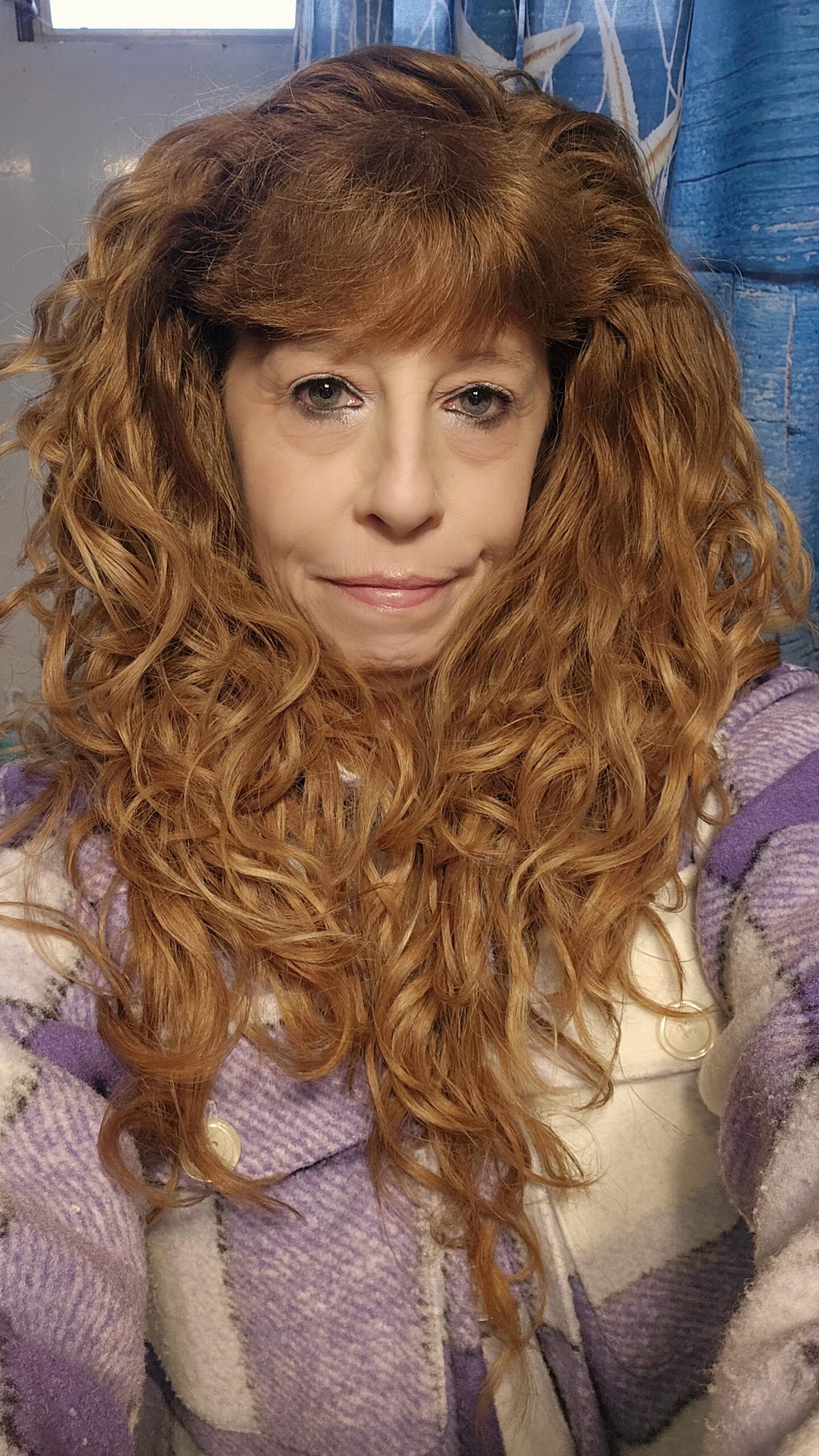 A woman with long, curly hair and a headband.