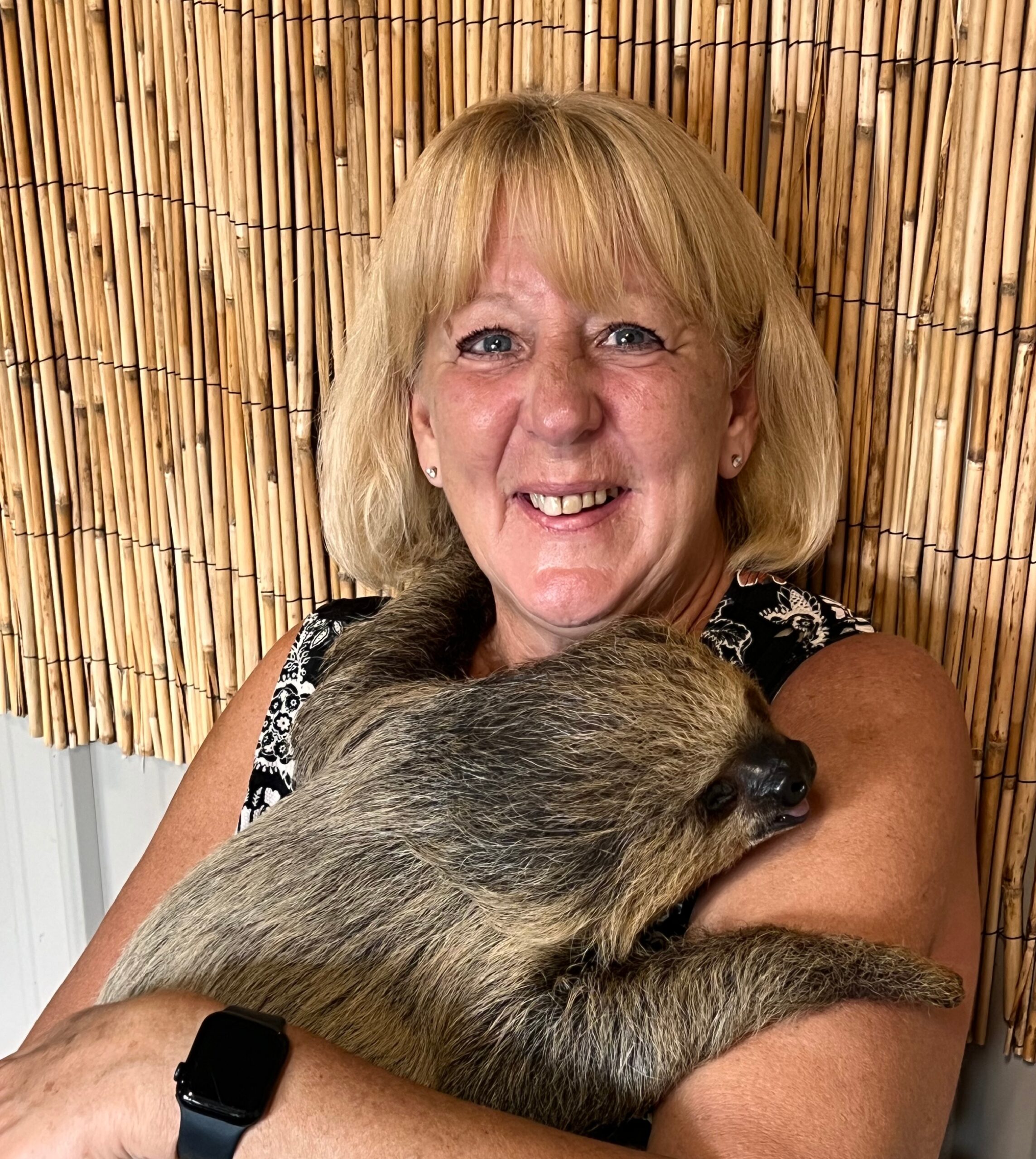 Kathy A woman holding a baby raccoon in her arms.